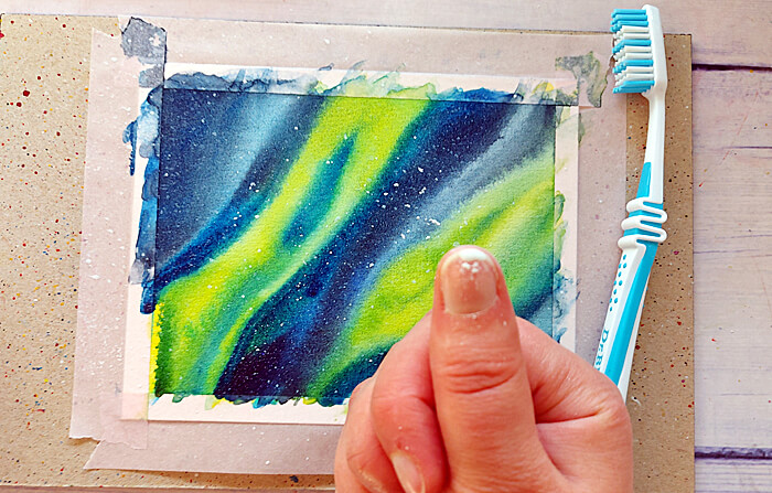 Nordlichter mit Aquarellfarben, Zahnbürste, Daumen mit weißen Farbflecken
