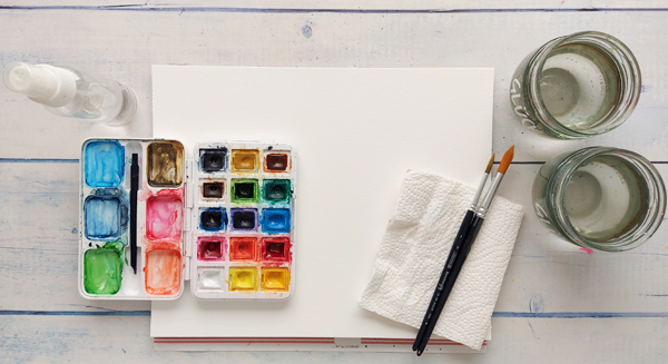 Aquarellpapier, zwei Pinsel, Aquarellfarben, zwei Wasserbecher