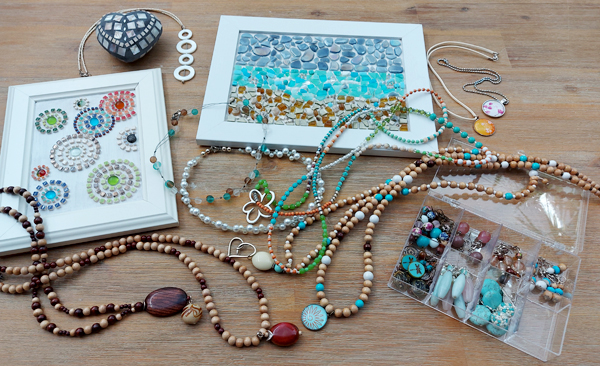 Mosaikbilder und handgefertigter Modeschmuck auf einem Tisch