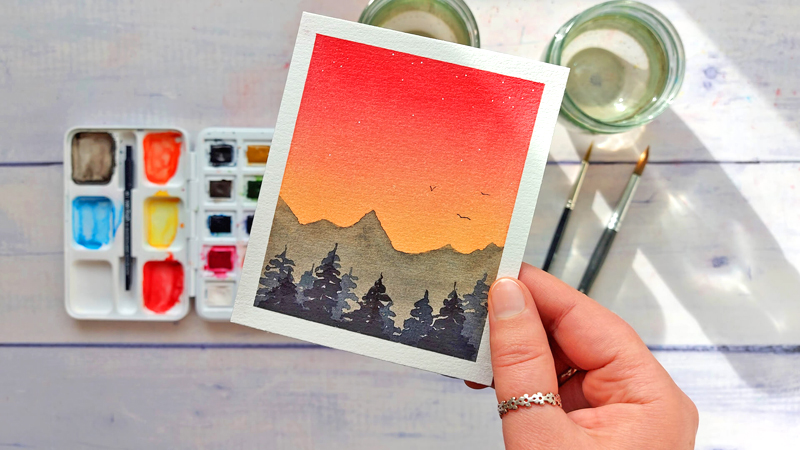 kleine Aquarell-Landschaft mit rötlichem Abendhimmel, Bergen, Tannen