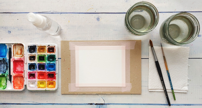 Aquarell-Material auf Tisch: Farbkasten, Papier, Pinsel, 2 Wasserbecher