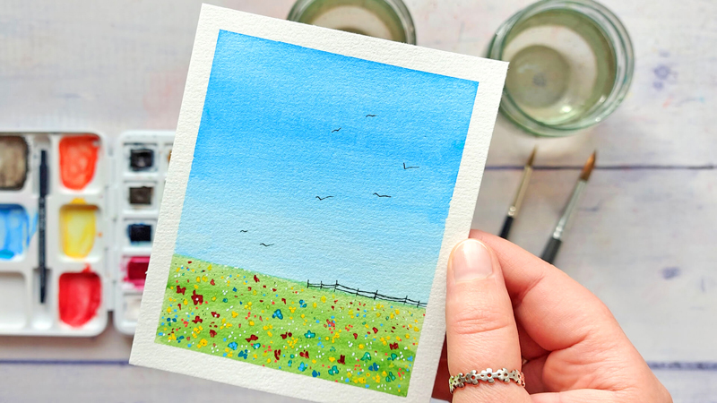 kleine Aquarell-Landschaft mit blauem Sommerhimmel und Blumenwiese