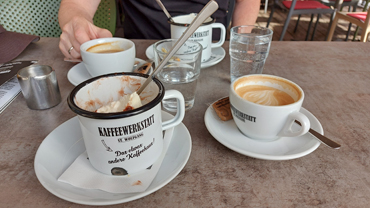 Emaille-Becher mit Eis und Sahne und Kaffeetasse