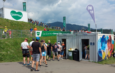 Menschenschlange vor mobilem WC-Wagen