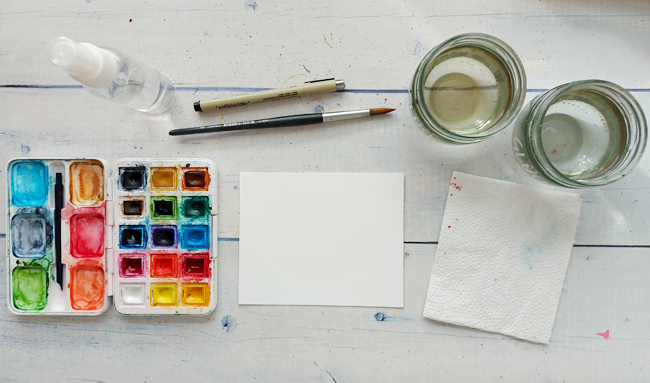 Aquarell-Material von Papier über Farbkasten bis Wasserbecher und Pinsel