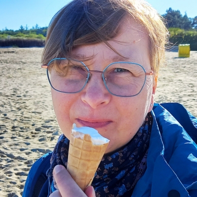 Frau isst ein Eis am Strand