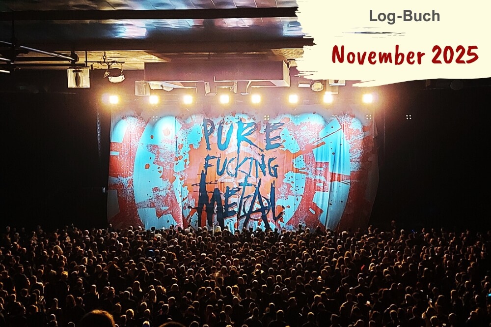 Volle Konzerthalle mit Blick auf Transparent auf Bühne mit Metal-Spruch