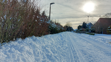 Winterstimmung in einem Wohnviertel mit Sonne im Dunst