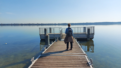 Frau auf einem Steg an einem See