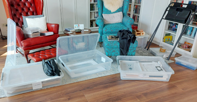 Offene Kunststoffkisten auf Boden vor zwei Lesesesseln