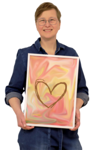 Frau hält Bild im Bilderrahmen vor sich, Bild ist rosa mit goldenem Herzen drauf