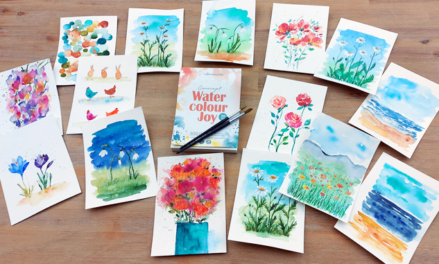 viele kleine Aquarellbilder ausgebreitet auf einem Holztisch