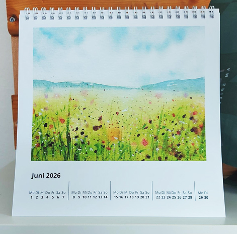 Kalenderblatt Juni 2026 mit Aquarellbild mit Blumenwiese, Bergkette unter blauem Himmel