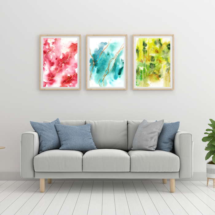 Drei abstrakte Aquarellbilder in Rot, Blau, Grn über grauem Sofa