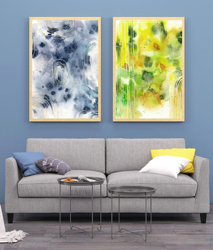 Zwei abstrakte Aquarellbilder in Grau und Grün über grauem Sofa