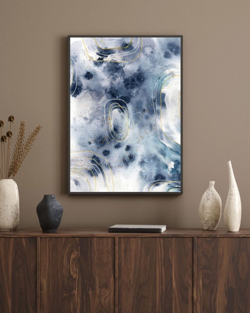 Abstraktes Aquarell in Grautönen an brauner Wand über dunklem Sideboard