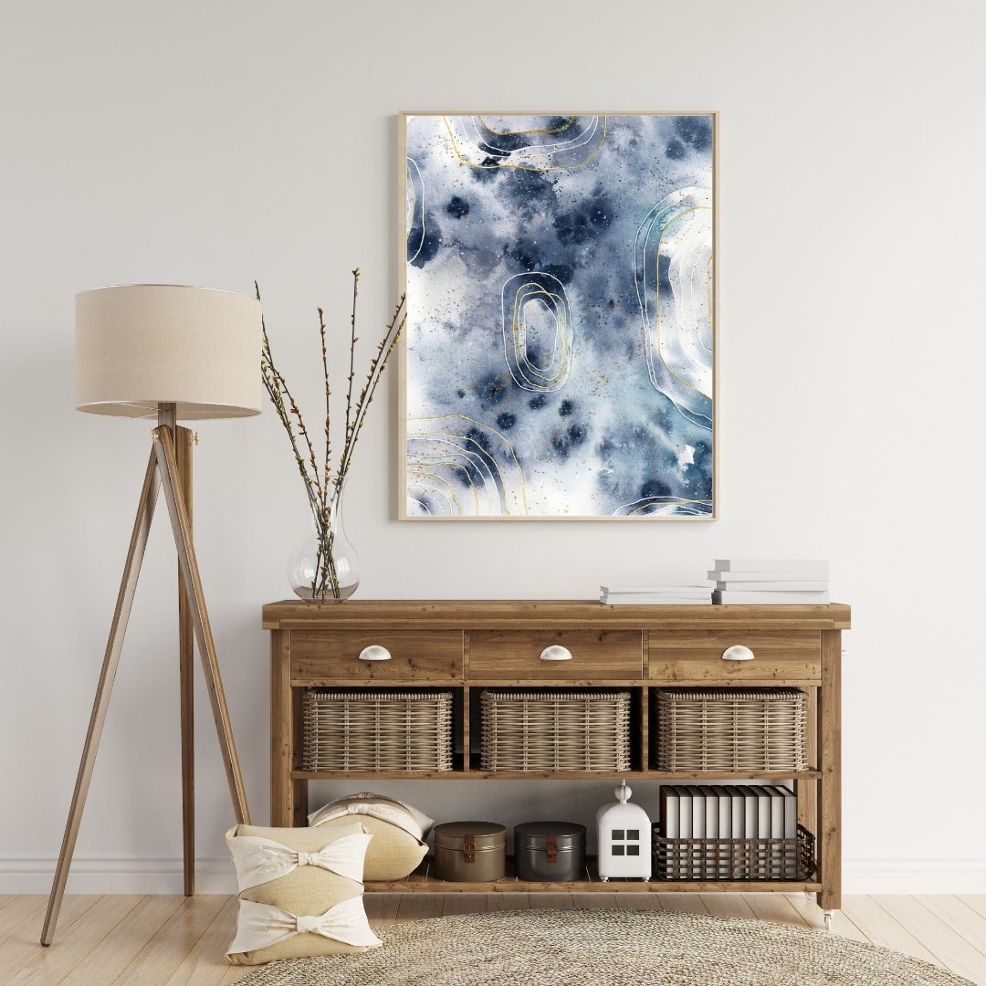 Abstraktes Aquarell in Grautönen über Sideboard mit Körben daneben Stehlampe