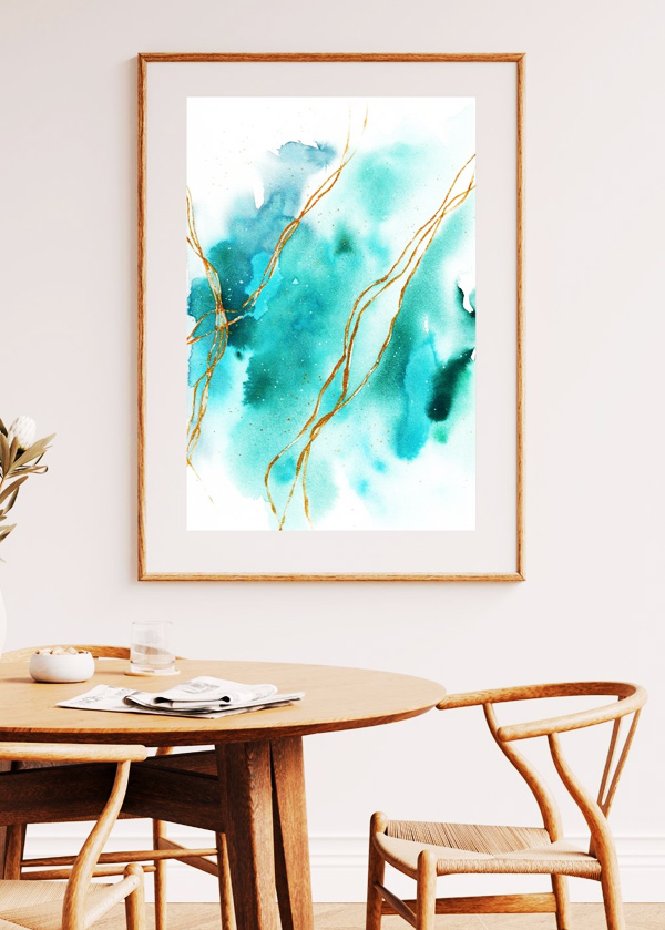 Abstraktes Aquarell in Blautönen mit goldenen Linien über hellem Holztisch mit Stühlen