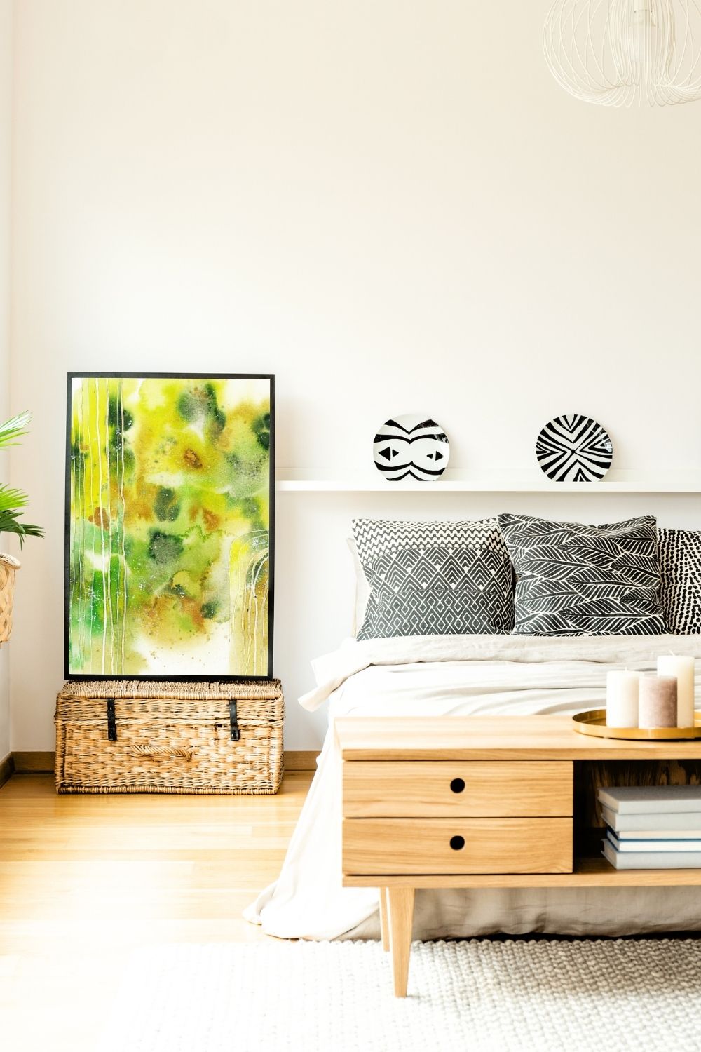 Abstraktes Aquarellbild in Grüntönen auf Truhe neben Bett
