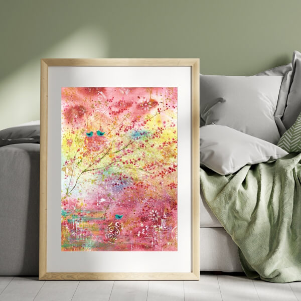 Halbabstraktes leuchtendes Aquarell mit Zweigen und Vögeln in den Farben Pink, Rosa, Gelb, Türkis lehnt an Bett mit grüner Decke