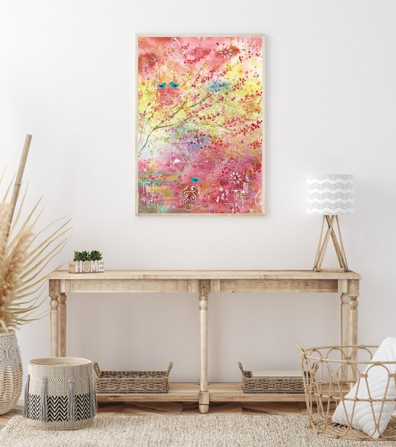 Halbabstraktes leuchtendes Aquarell mit Zweigen und Vögeln in den Farben Pink, Rosa, Gelb, Türkis über hellem Tisch