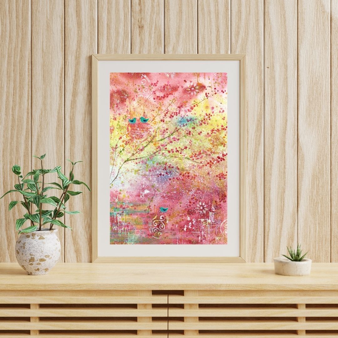 Halbabstraktes leuchtendes Aquarell mit Zweigen und Vögeln in den Farben Pink, Rosa, Gelb, Türkis über hellem Holzsideboard