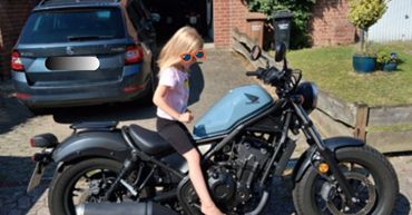 junges Mädchen sitzt auf Motorrad